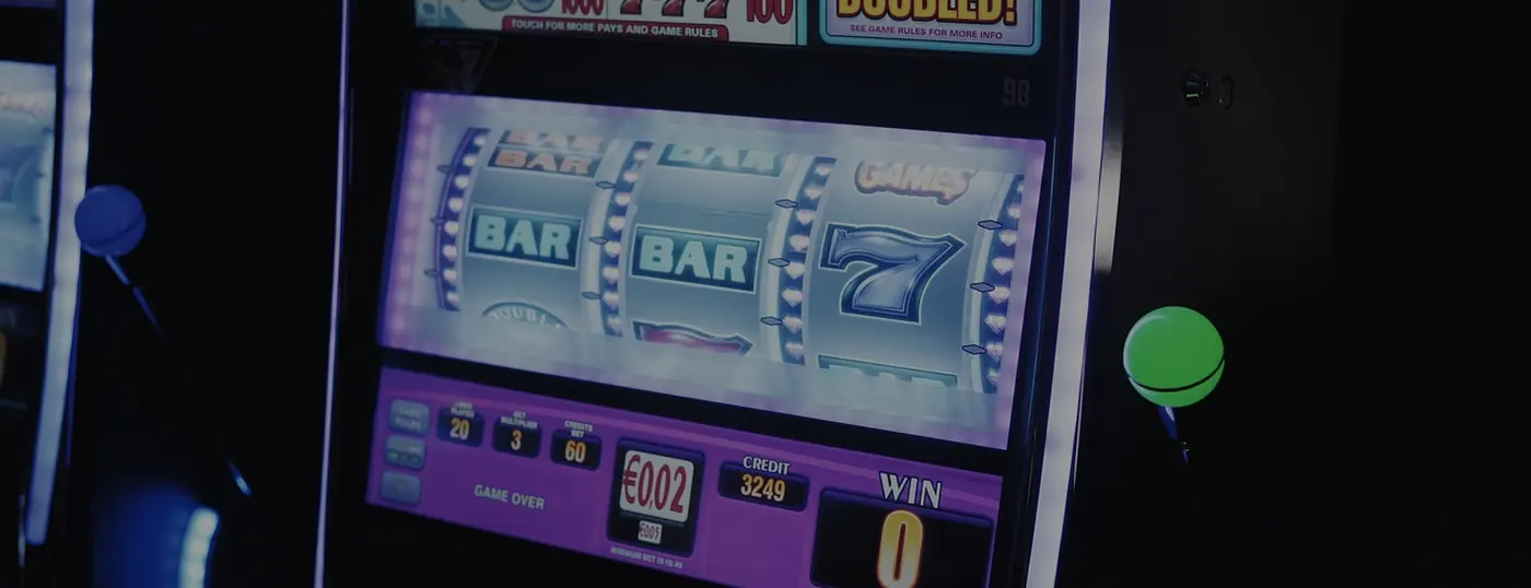 A slot machine lit up on a darkened casino floor
